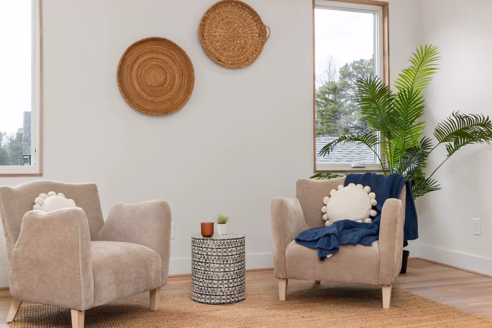 Two comfortable armchairs by a window in a calm, neutral room